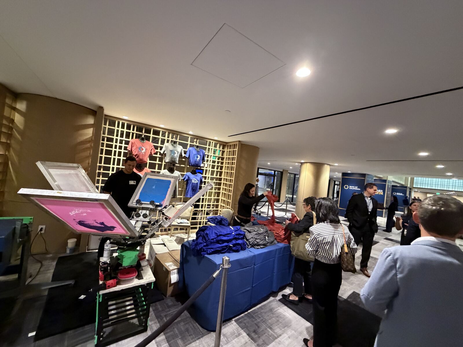 Busy event booth with printed merchandise stocked and staff helping guests