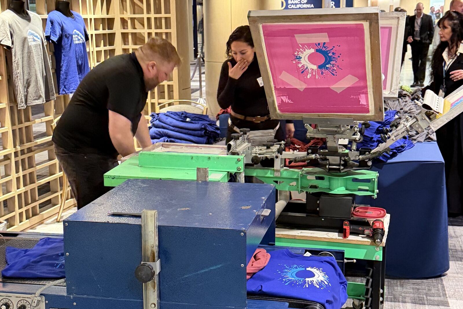 Live DTF printing station heat pressing a full-color transfer onto event swag